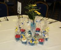 A beautiful floral arrangement and an array of delicous cup cakes